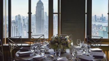 An elegantly set table, situated before windows overlooking New York City, awaits attendees of The Society of MSK’s Fall Lunch. 