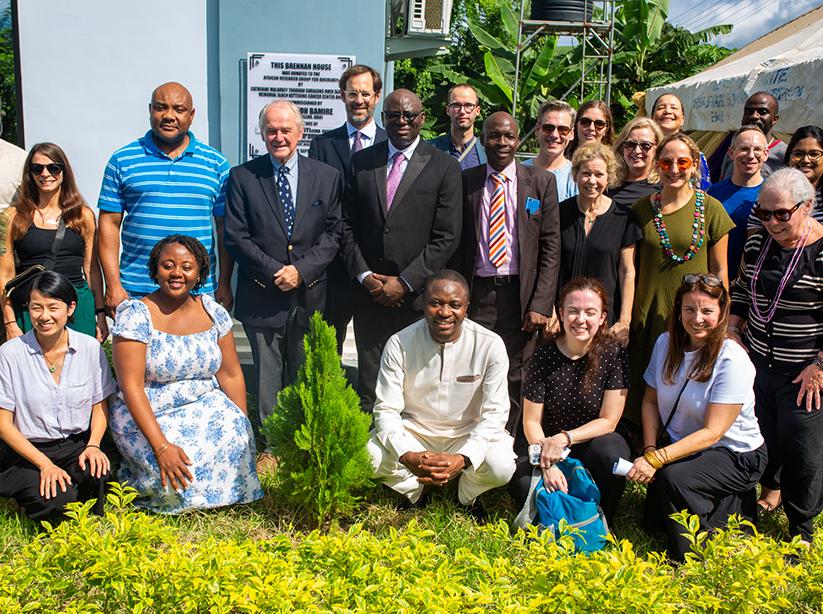Members of what is now the GCRT Program gather together in Nigeria. A sign behind them reads “The Brennan House.”