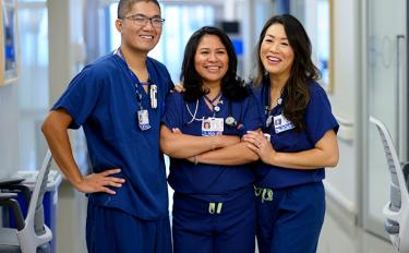 Three MSK nurse anesthetists stand together in a hallway at MSK, where they help patients every day.
