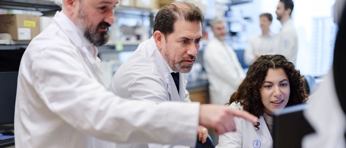 MSK gastrointestinal oncologist Luis Diaz Jr., MD, an expert in colorectal cancer research and care, in an MSK lab with two colleagues.