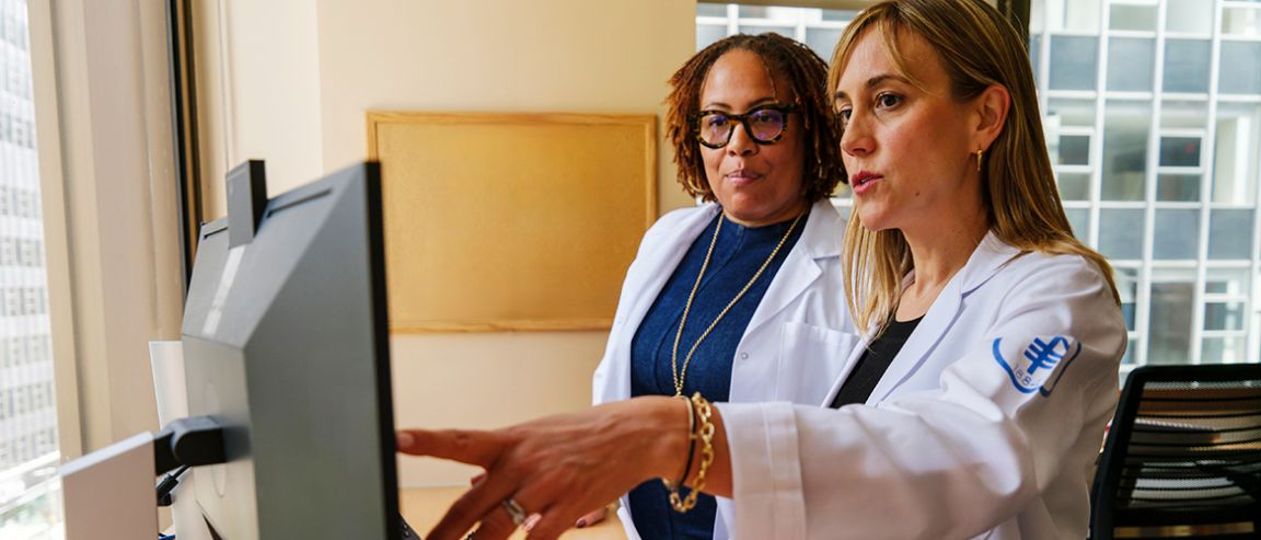 Two MSK doctors look at an image on a computer screen. The doctor on the right is pointing at something on the screen.