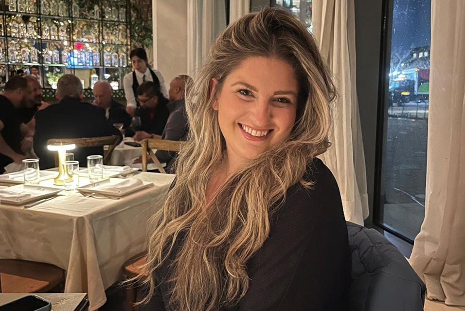 Woman posing and smiling for a photo in a restaurant 