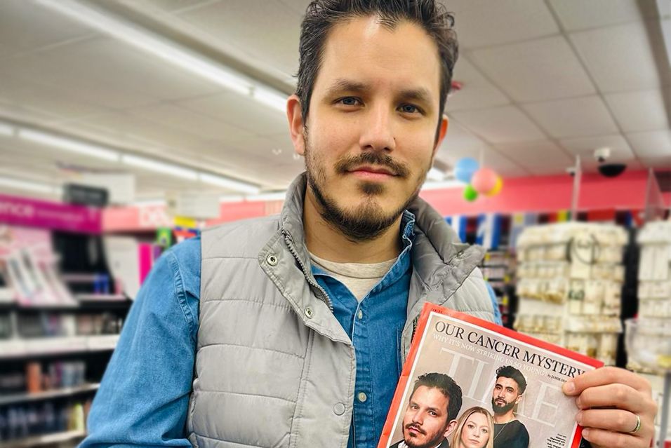 MSK lung cancer patient Giancarlo holds up an issue of Time magazine that features him and other MSK patients on the cover. 