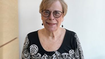 MSK donor and cancer research supporter Sydney F. stands, smiling. 