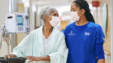 MSK nurse and patient walking together, looking at each other and smiling 