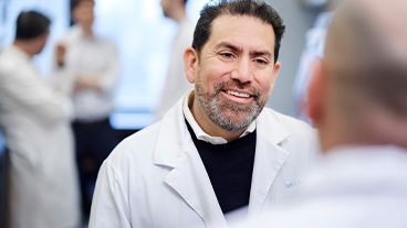 MSK physician Luis Diaz Jr., MD, in an MSK lab speaking with a colleague.