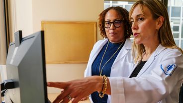 Two MSK doctors look at an image on a computer screen. The doctor on the right is pointing at something on the screen.
