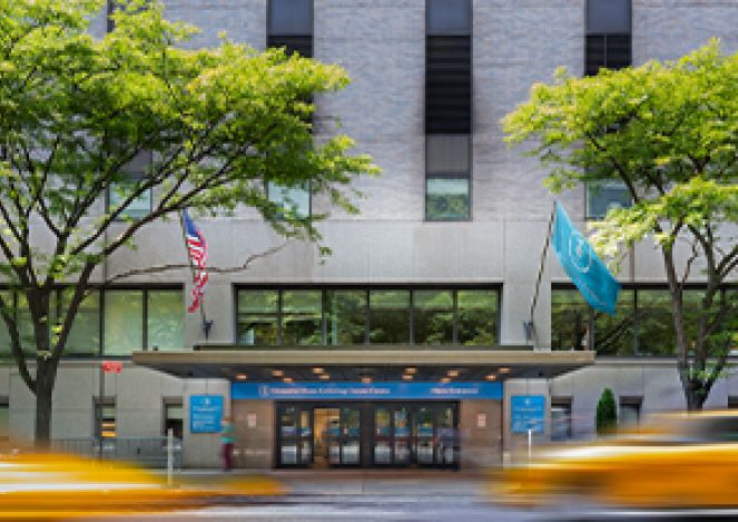 Street view of the MSK entrance with blurred yellow cabs passing by.